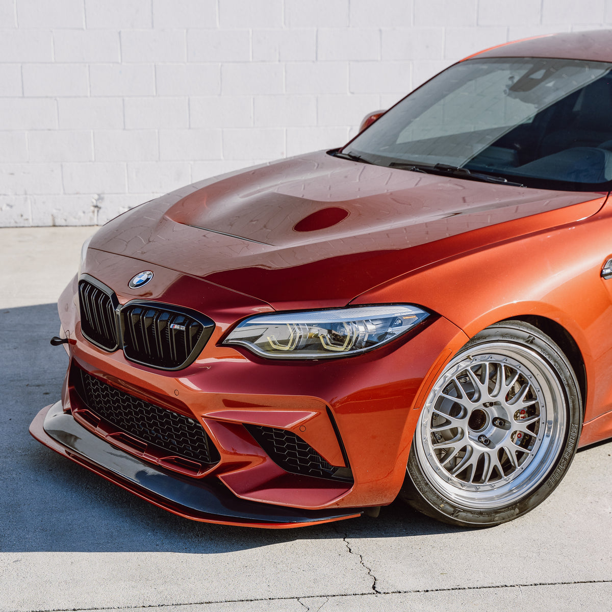 Front-end detail of a BMW F87 M2 Competition with carbon fiber front splitter installed