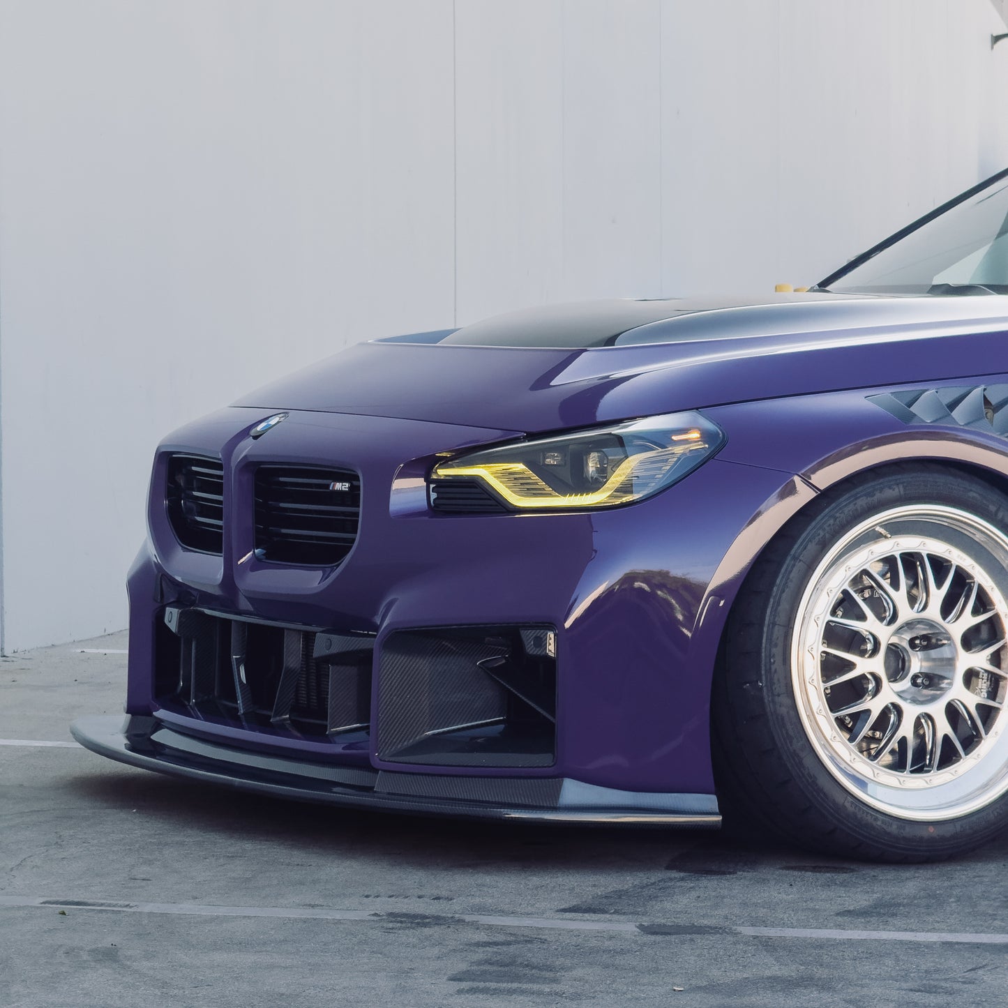 Front view of an Ultraviolet BMW G87 M2 equipped with the Ridgeline Motorsport GT4 carbon fiber front lip