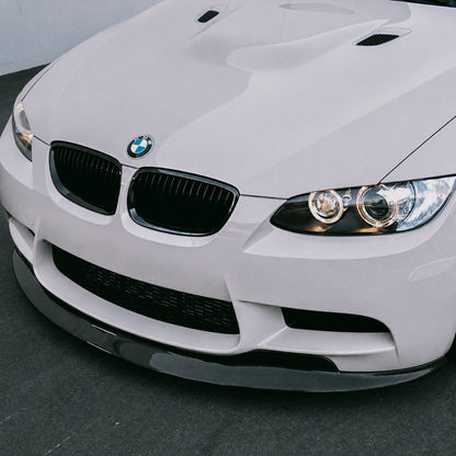 AlpineX Dynamics GTS Style Carbon Fiber Front Lip installed on a BMW E9X M3, shown in a close-up view highlighting its glossy carbon fiber finish and detailed fitment.