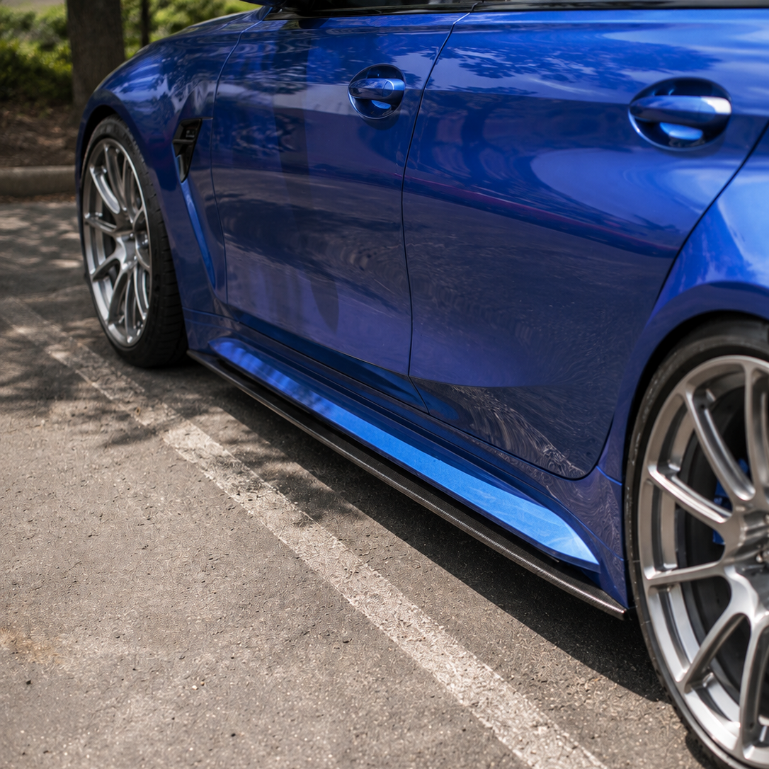 AlpineX Dynamics R44 Style Carbon Fiber Side Skirt installed on a BMW G80 M3, featuring a glossy carbon fiber finish and an aggressive side profile enhancement.