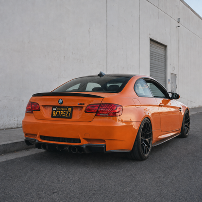 AlpineX Dynamics V Style Carbon Fiber Rear Diffuser installed on a BMW E92 M3, featuring a glossy carbon fiber finish and an aggressive rear-end design.