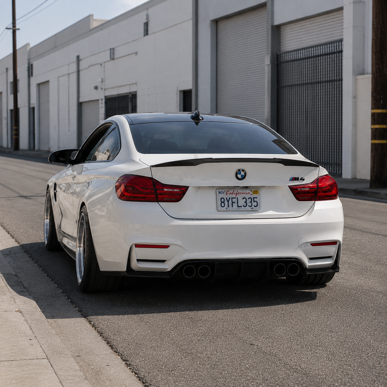 AlpineX Dynamics V Style Carbon Fiber Rear Diffuser installed on a white BMW F8X M3/M4, shown from the rear three-quarter view.