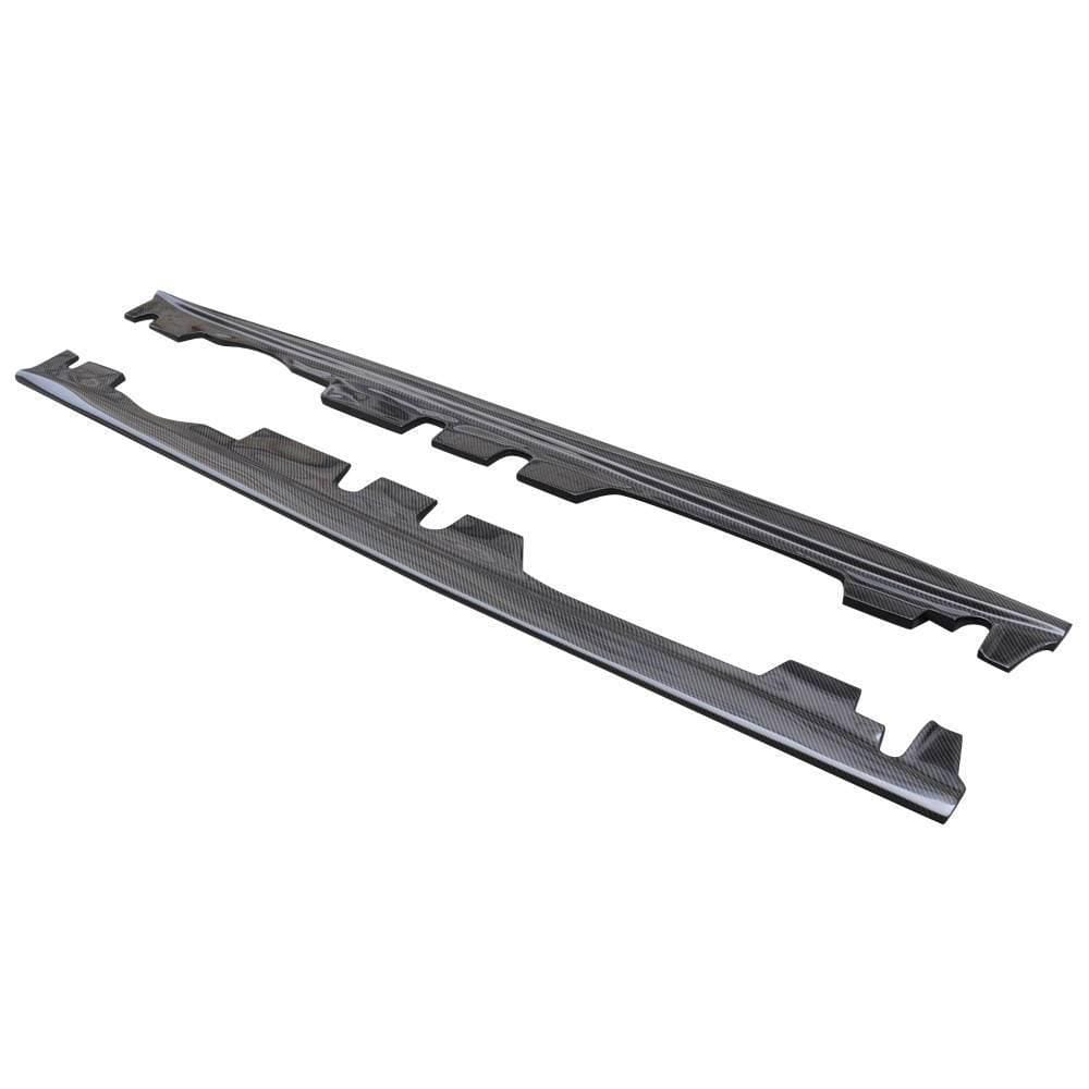 Angled product view of the AlpineX Dynamics MP style carbon fiber side skirt pair for the BMW E9X M3, showing the long profiles and mounting cutouts