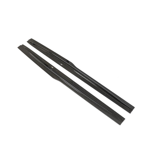 Angled product view of AlpineX Dynamics PSM style carbon fiber side skirts for BMW F80 M3 and F82/F83 M4, showing both sculpted extensions and mounting slots on white