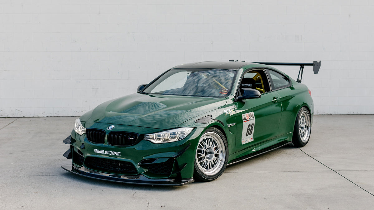 Green BMW F82 M4 GT4+ development car with carbon fiber front splitter and rear wing