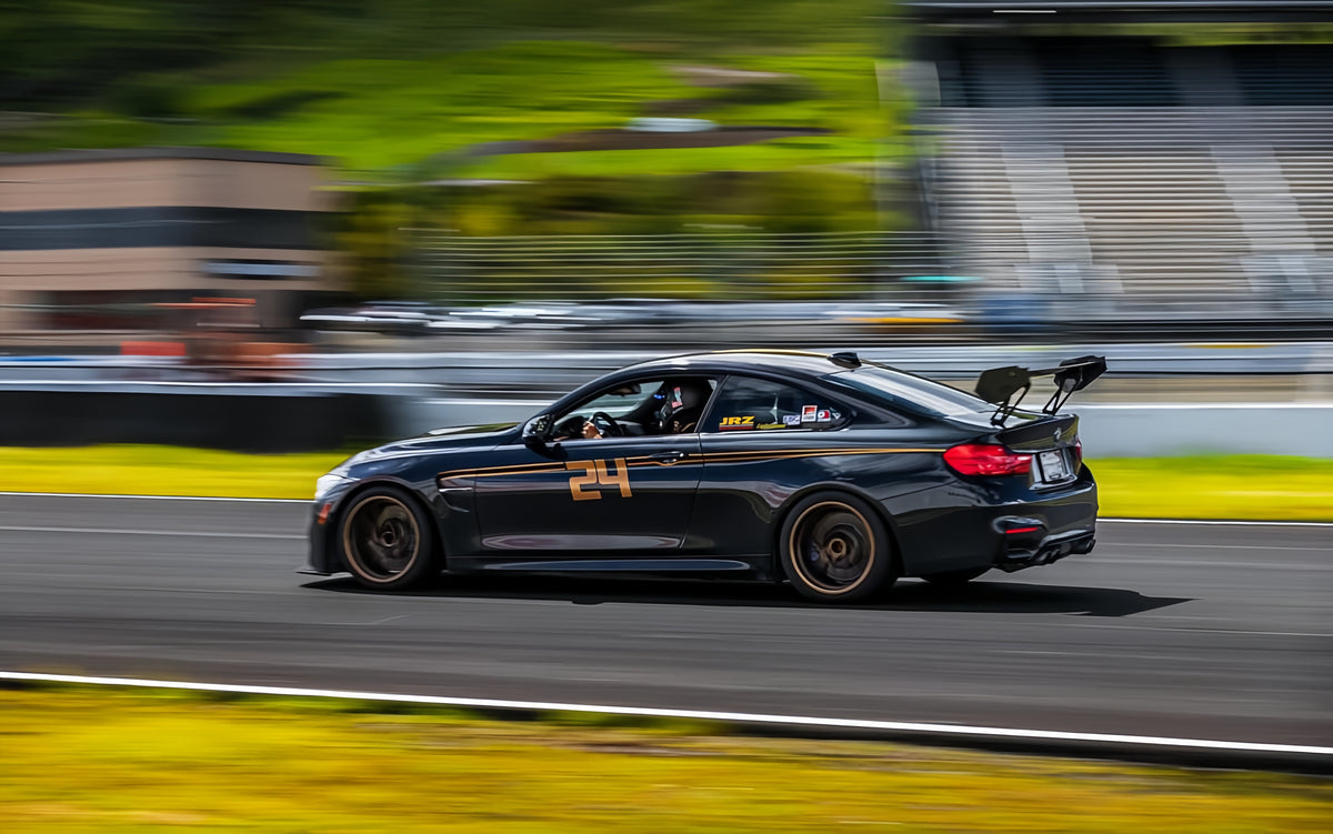 BMW F82 M4 running an M235iR carbon fiber rear wing on track