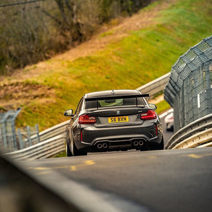 BMW F87 M2 with Ring Spec Wing V2 viewed from the rear on track