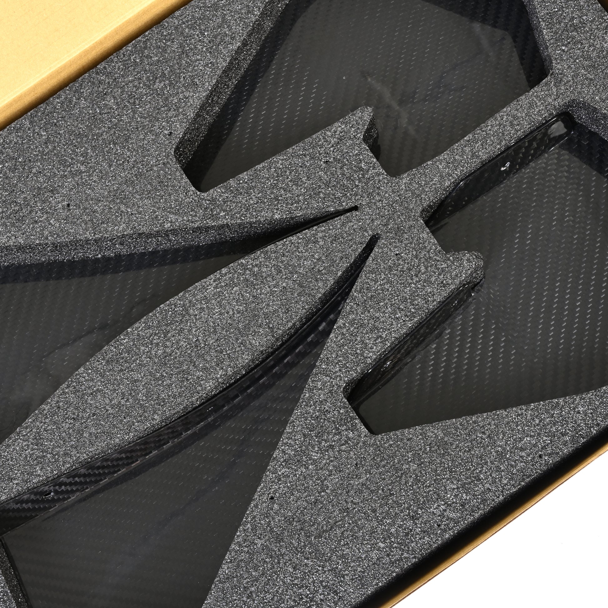 Close-up of the four GT4+ carbon fiber canards in protective foam packaging for the BMW F8X M3 and M4