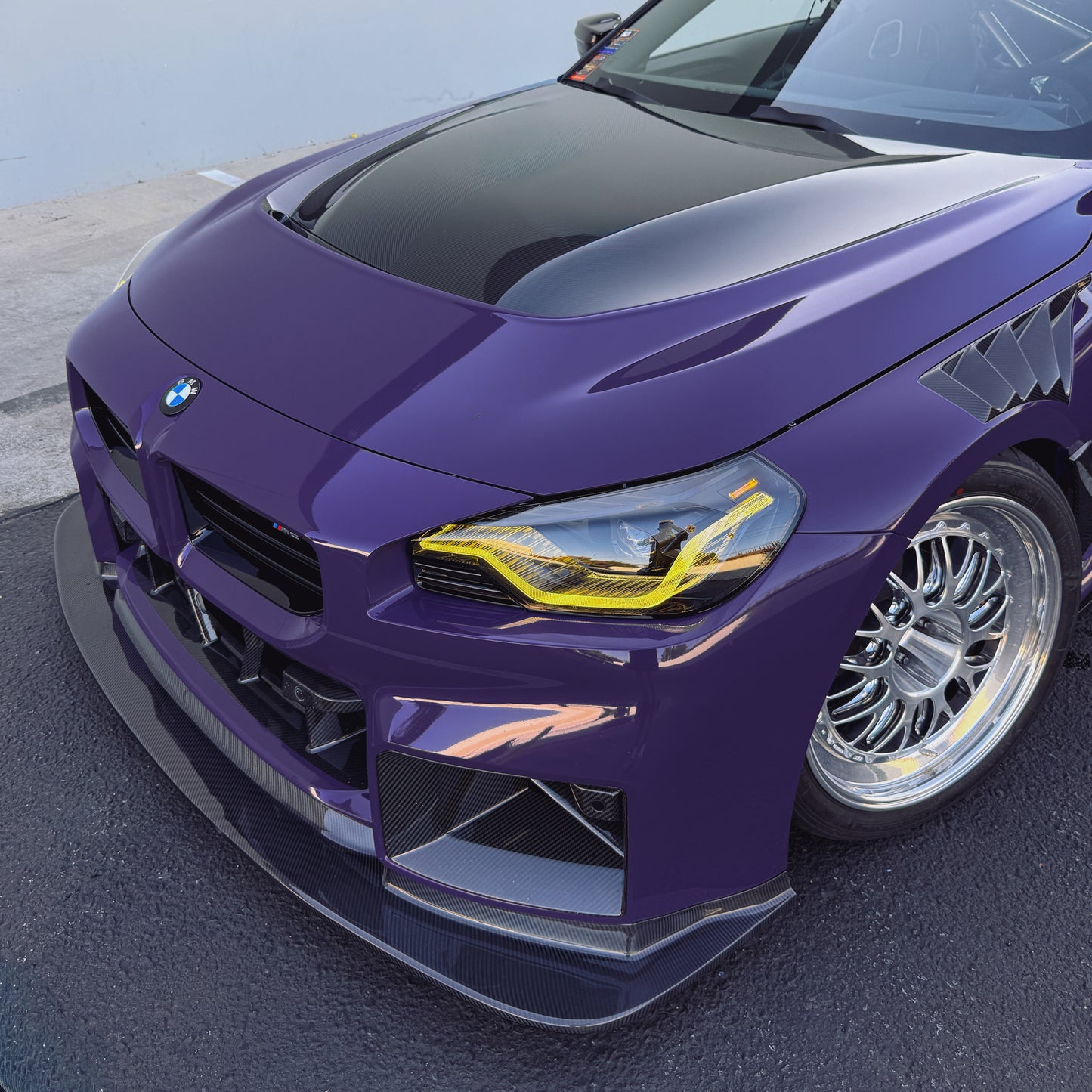 BMW G87 M2 GT4 bumper-mounted carbon fiber front lip showing its extended corner profile