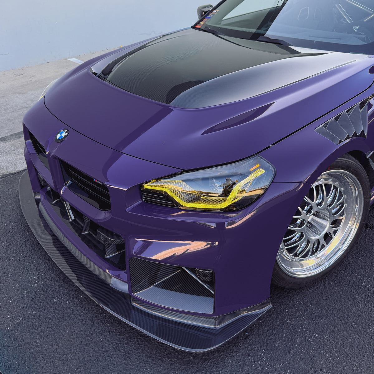 BMW G87 M2 GT4 bumper-mounted carbon fiber front lip showing its extended corner profile