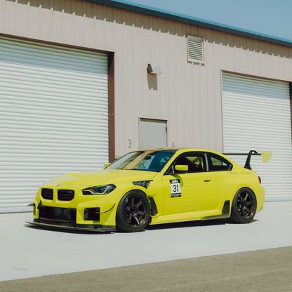 Yellow BMW G87 M2 fitted with GT4+ carbon fiber canards, front splitter and rear wing