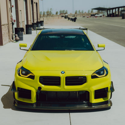 Straight front view of a BMW G87 M2 showing the two-piece GT4+ carbon fiber canard configuration
