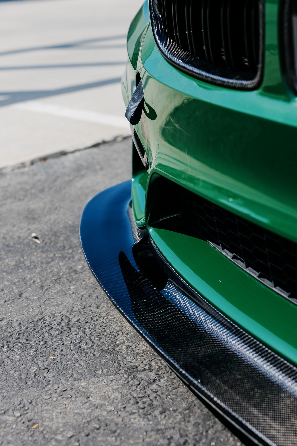 Side detail showing the approximately 4-inch extension of the F8X GT4 V2 front splitter