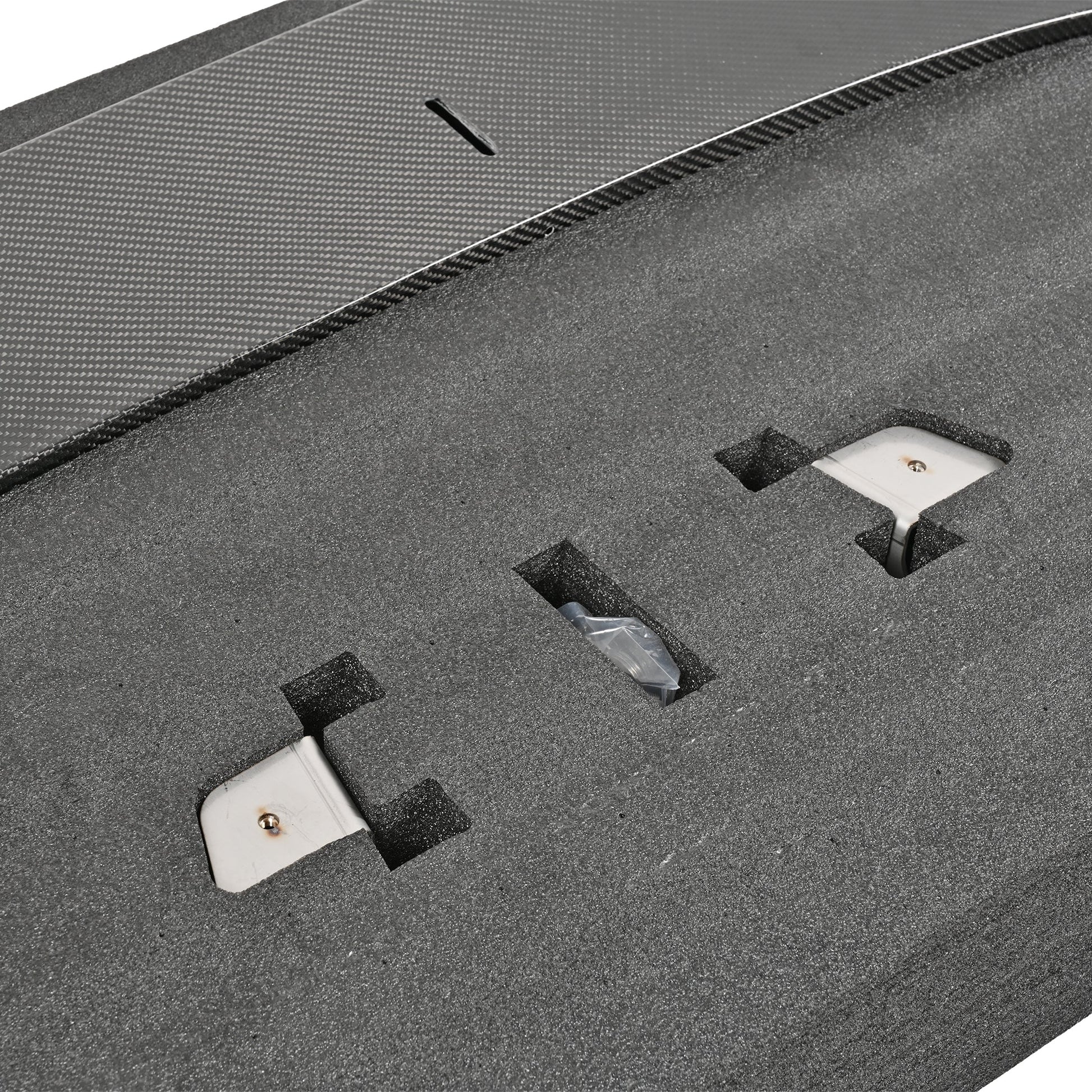 Close-up of the G87 M2 adjustable front splitter mounting hardware and carbon fiber adjustment slot in protective packaging