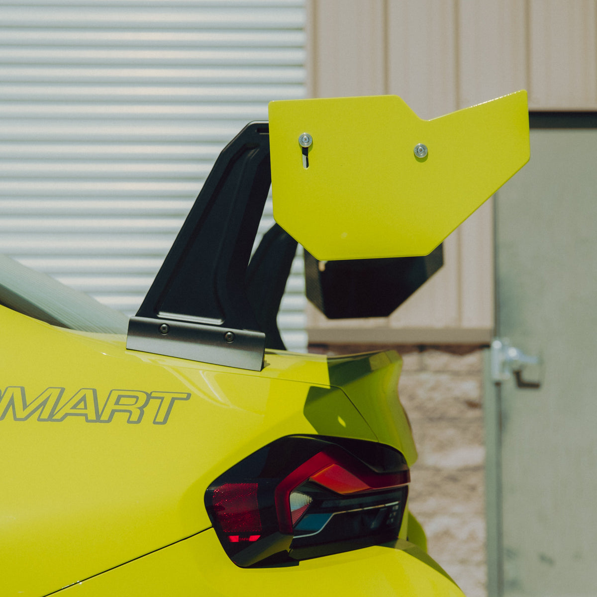 Close-up of the BMW G87 M2 GT4+ rear wing endplate, adjustment hardware and swan-neck upright