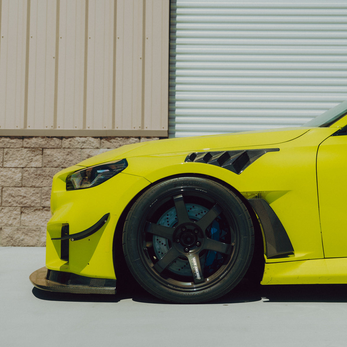 Side view of the GT4+ carbon fiber front bumper canard installed on a BMW G87 M2