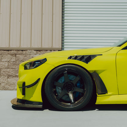 Side view of the GT4+ carbon fiber front bumper canard installed on a BMW G87 M2