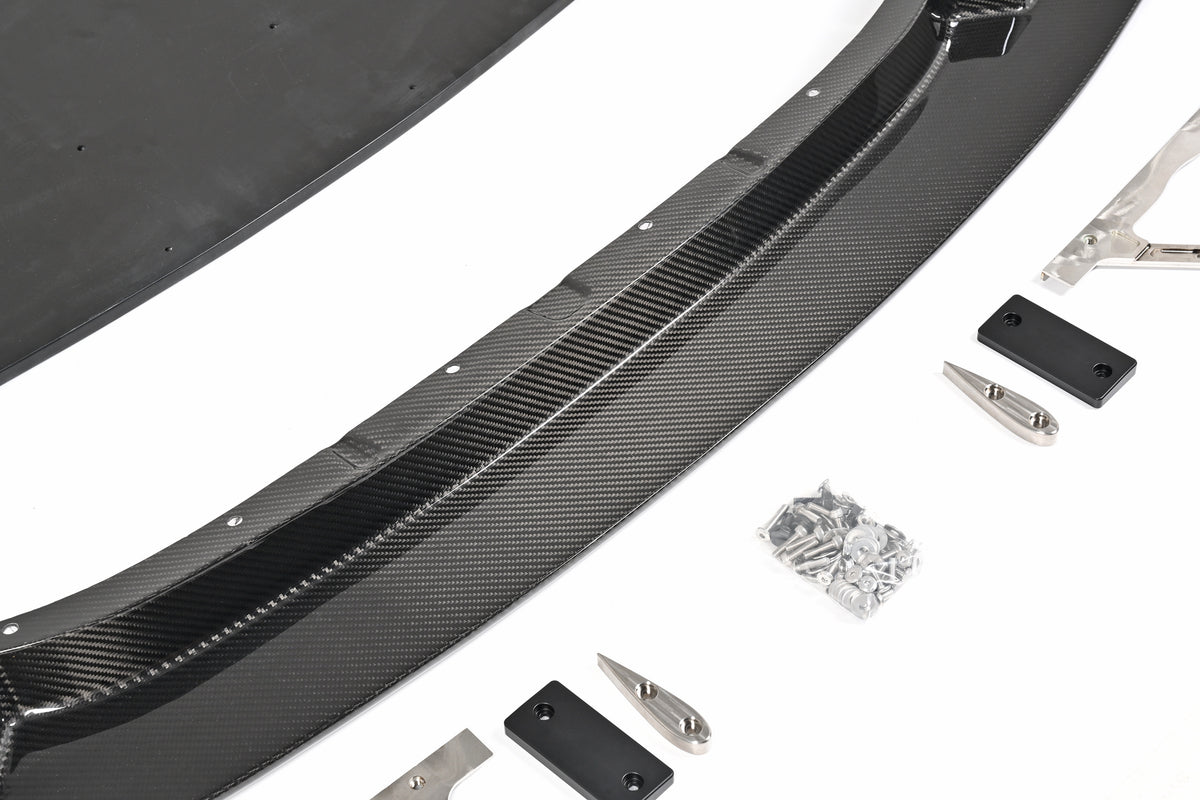 Close-up of the BMW G87 M2 GT4+ pre-preg carbon fiber front lip, skid blocks and installation hardware