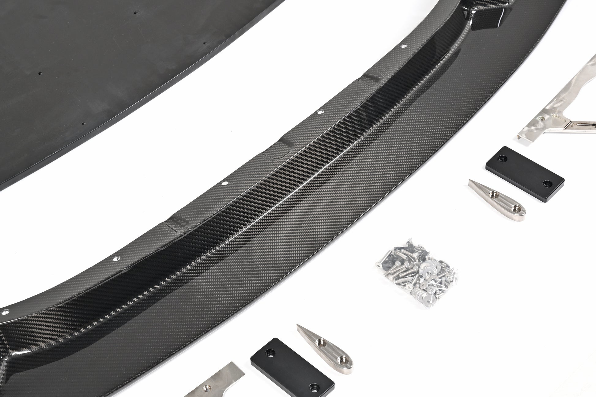Close-up of the BMW G87 M2 GT4+ pre-preg carbon fiber front lip, skid blocks and installation hardware