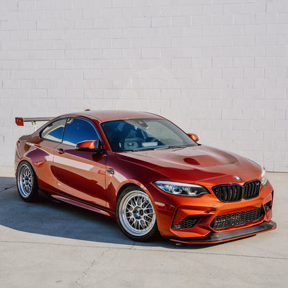 Orange BMW F87 M2 Competition with adjustable front splitter in a full three-quarter view