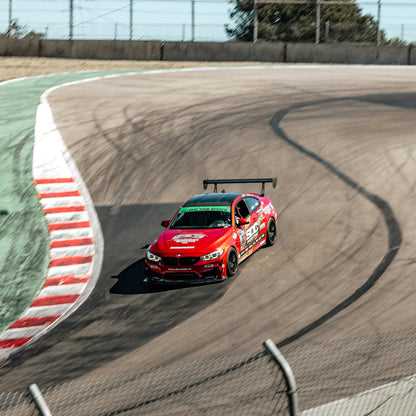Red BMW F80 M3 with GT4+ front splitter and rear wing driving on track
