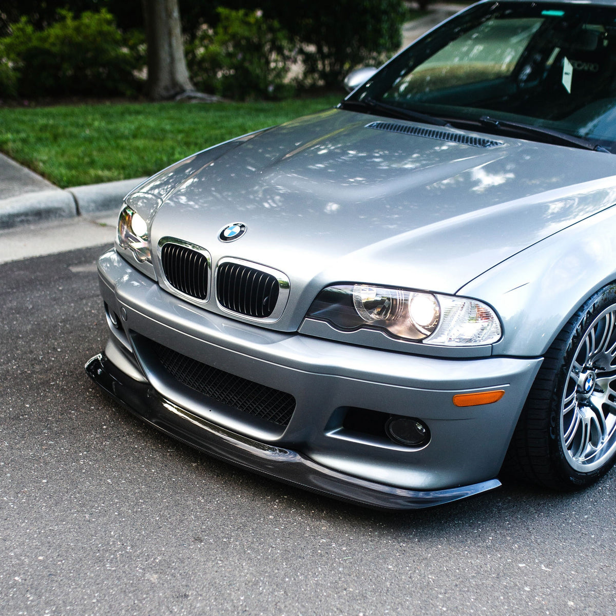 Silver BMW E46 M3 with GT4 carbon fiber front lip installed