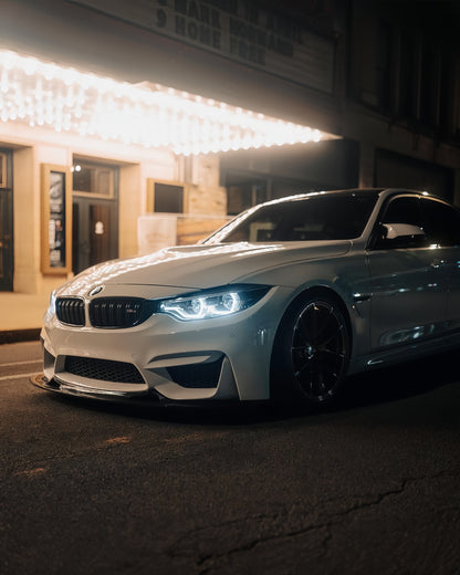 Silver BMW F82 M4 with GT4 V1 carbon fiber front splitter photographed at night