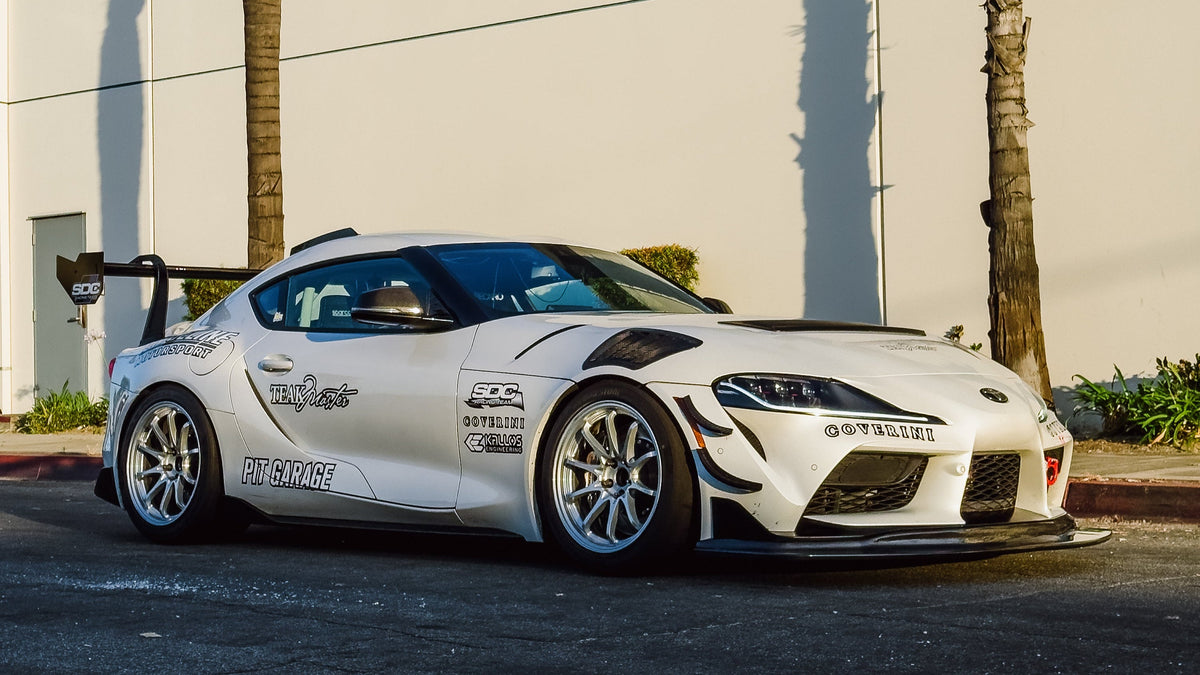 White Toyota A90 Supra GT4+ development car with front splitter, canards, hood vent and chassis-mounted rear wing