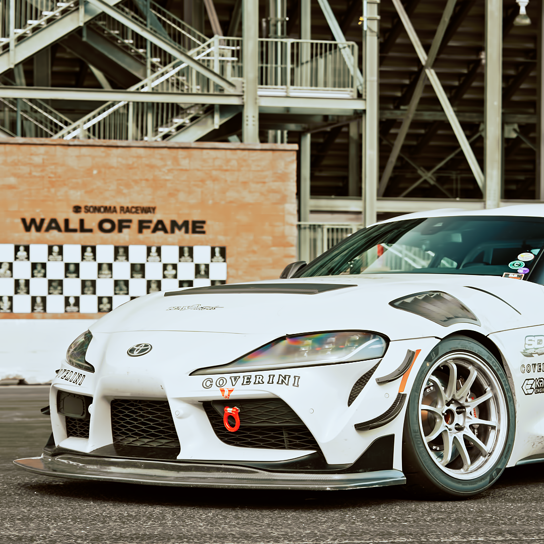 Front three-quarter view of a Toyota GR Supra A90 with GT4+ splitter kit and carbon fiber canards installed
