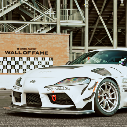 Front three-quarter view of a Toyota GR Supra A90 with GT4+ splitter kit and carbon fiber canards installed