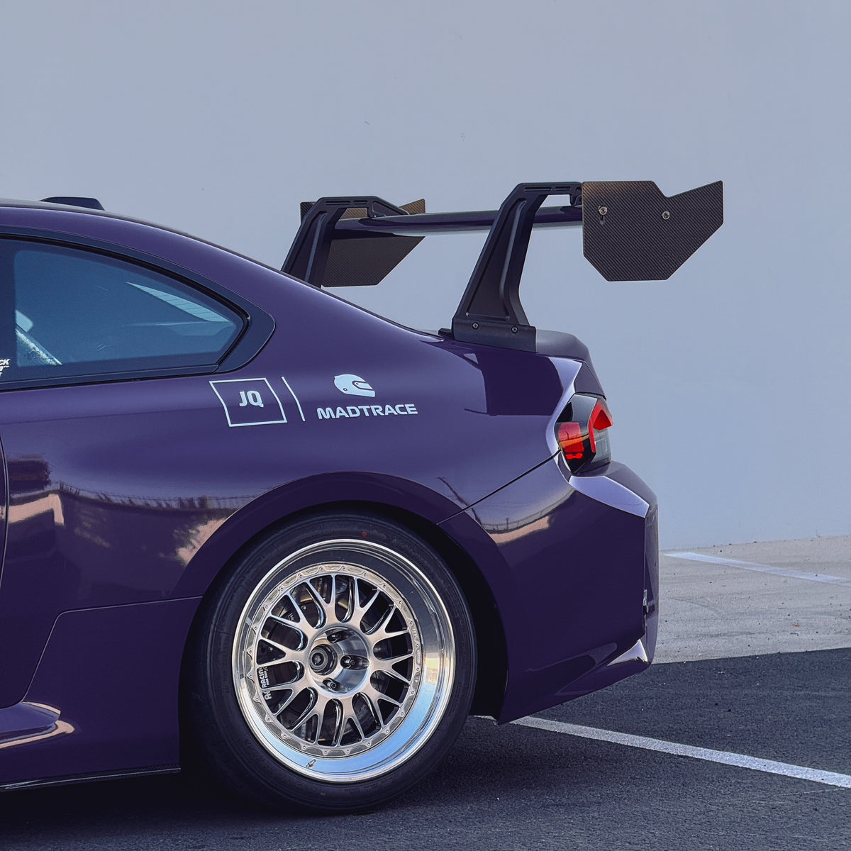 Side view of an Ultraviolet BMW G87 M2 with the GT4+ carbon fiber swan-neck rear wing installed