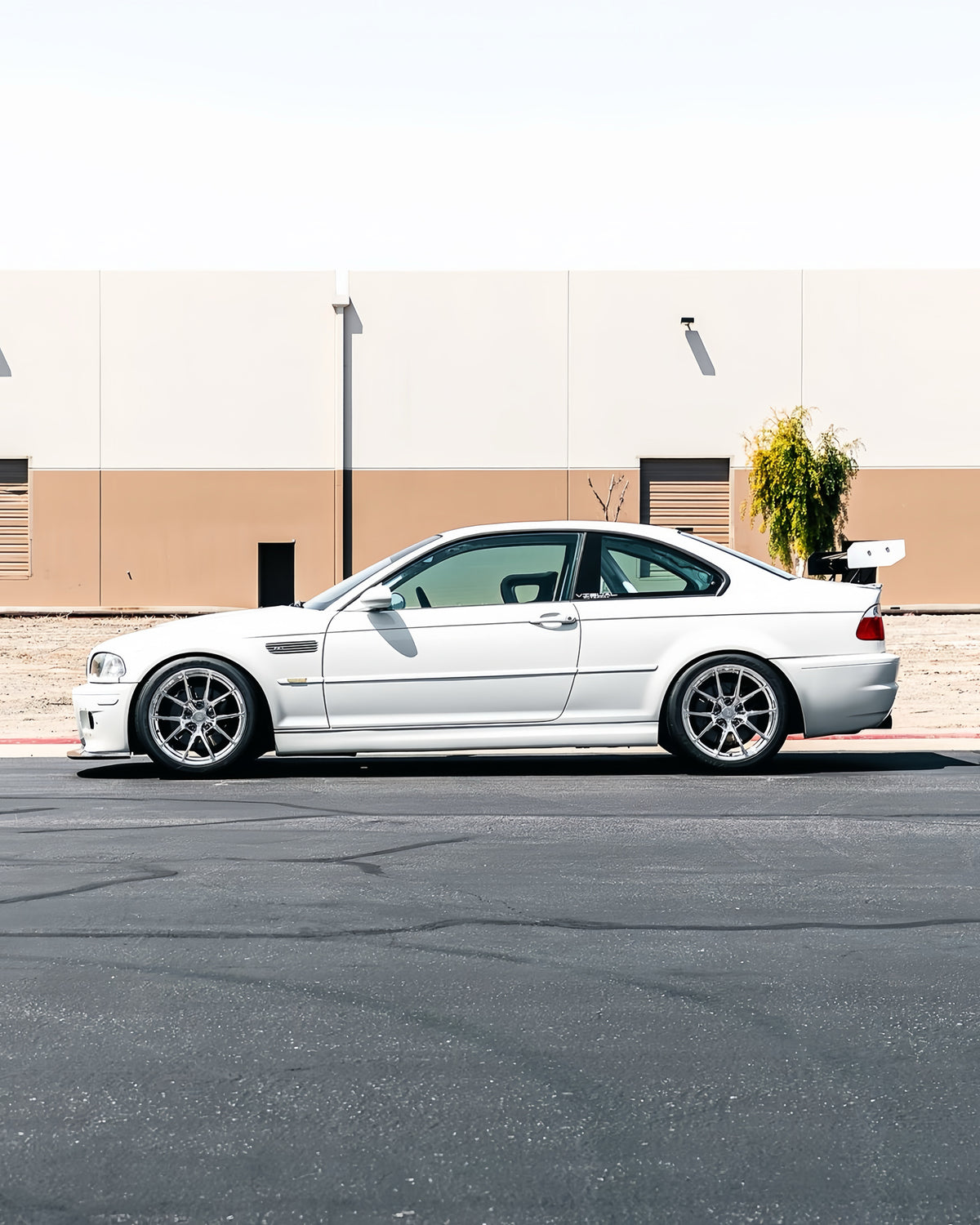 Side profile of white BMW E46 M3 showing extended GT4 front lip